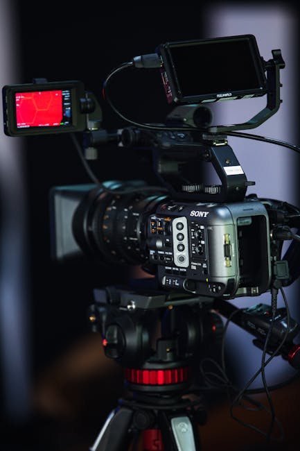 Close-up of a high-end video camera with multiple monitors for filming projects.