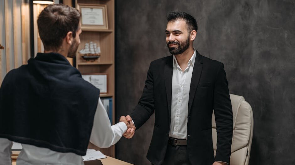 Two businessmen shaking hands in a modern office, sealing a business deal.